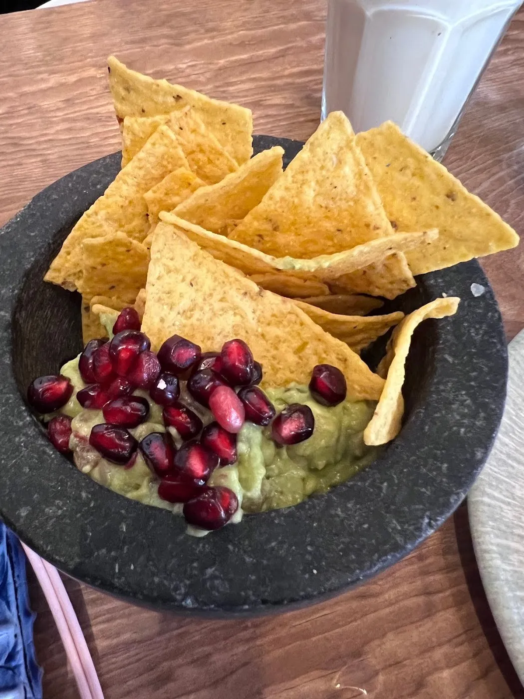 Cuenco de piedra con guacamole, granada y nachos