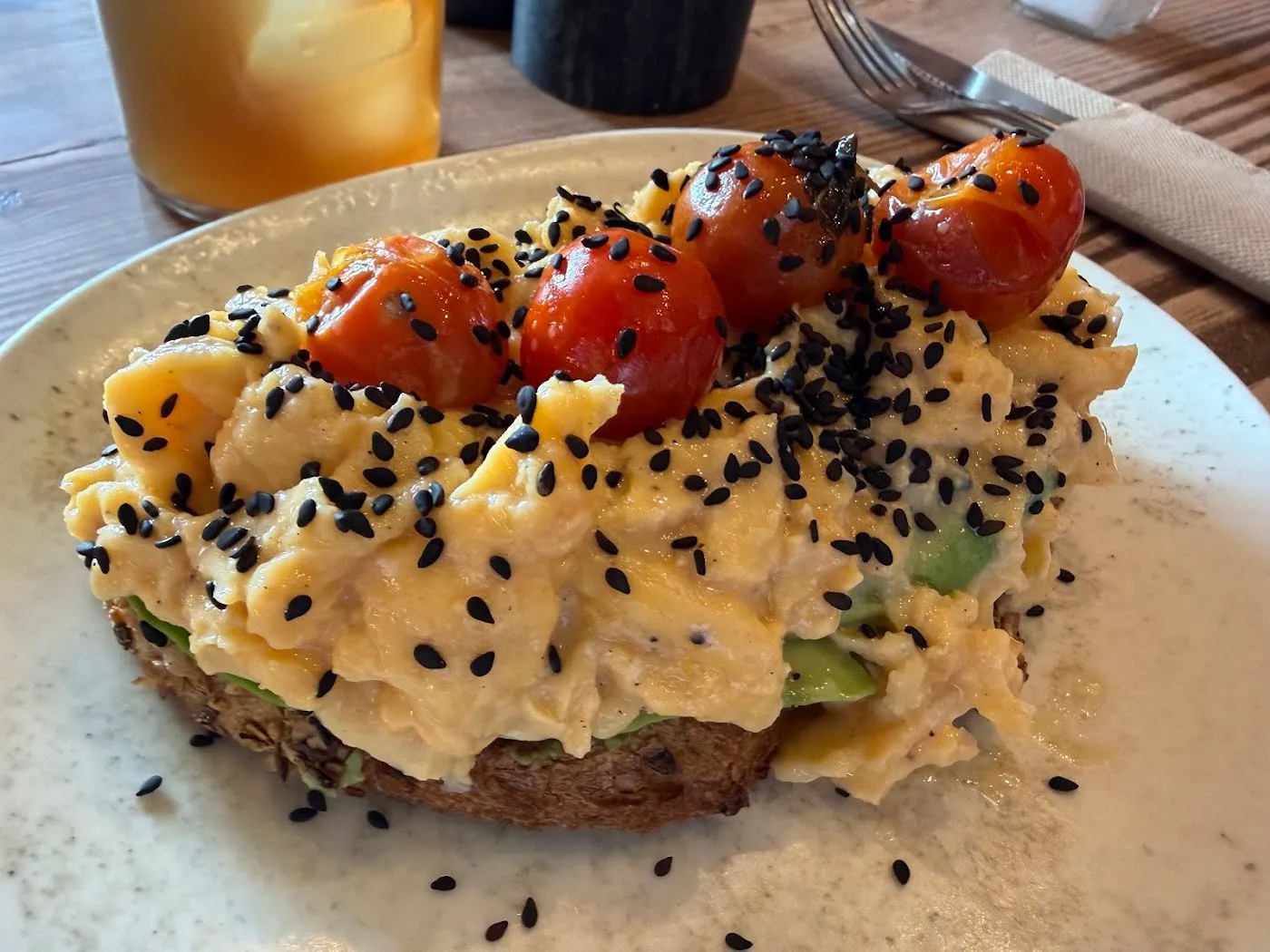 Tosta de huevos revueltos con tomates cherry y sésamo negro
